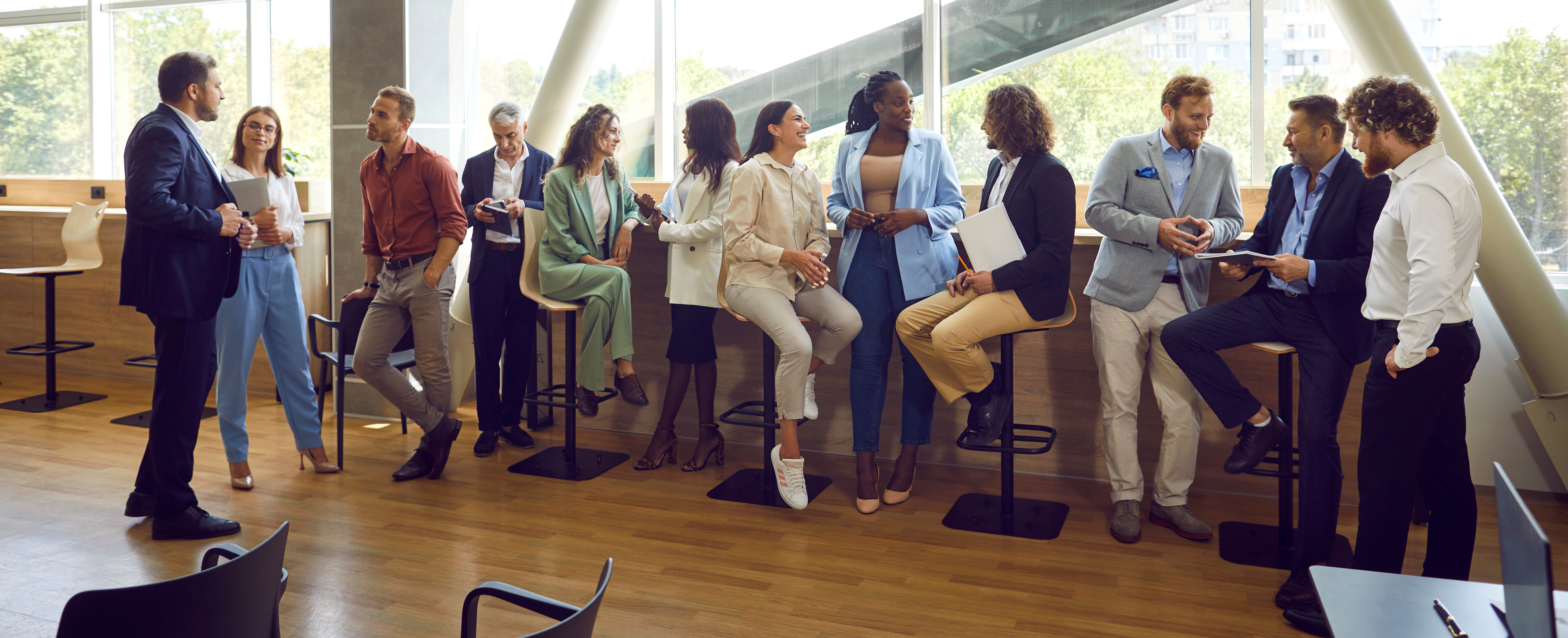 Group of diverse business people standing and talking in front of a window